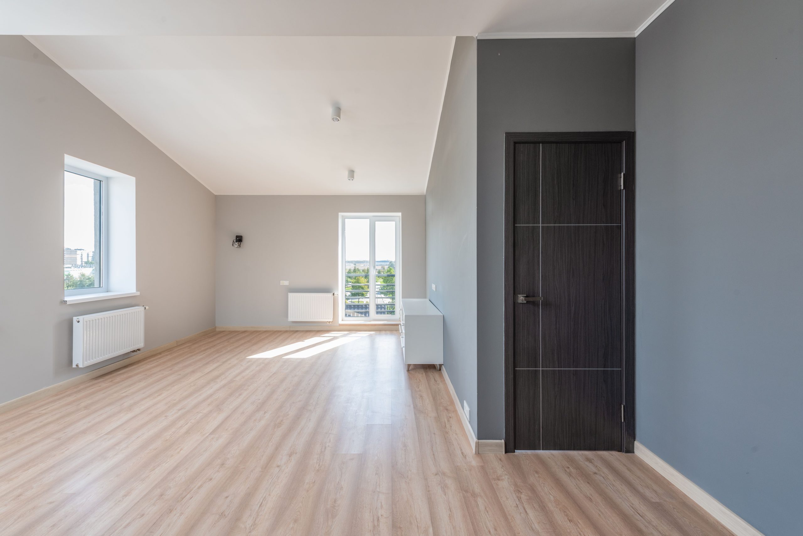 Pièce vide avec parquet et grandes fenêtres