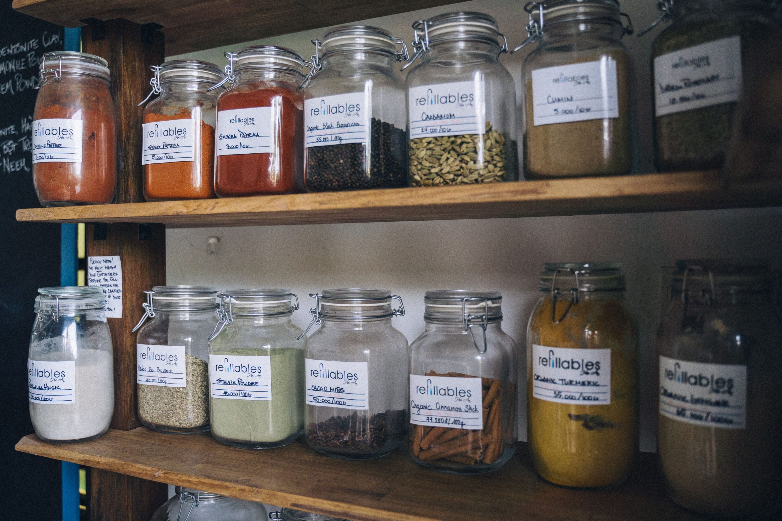 Pots à épices étiquetés rangés sur étagère en bois
