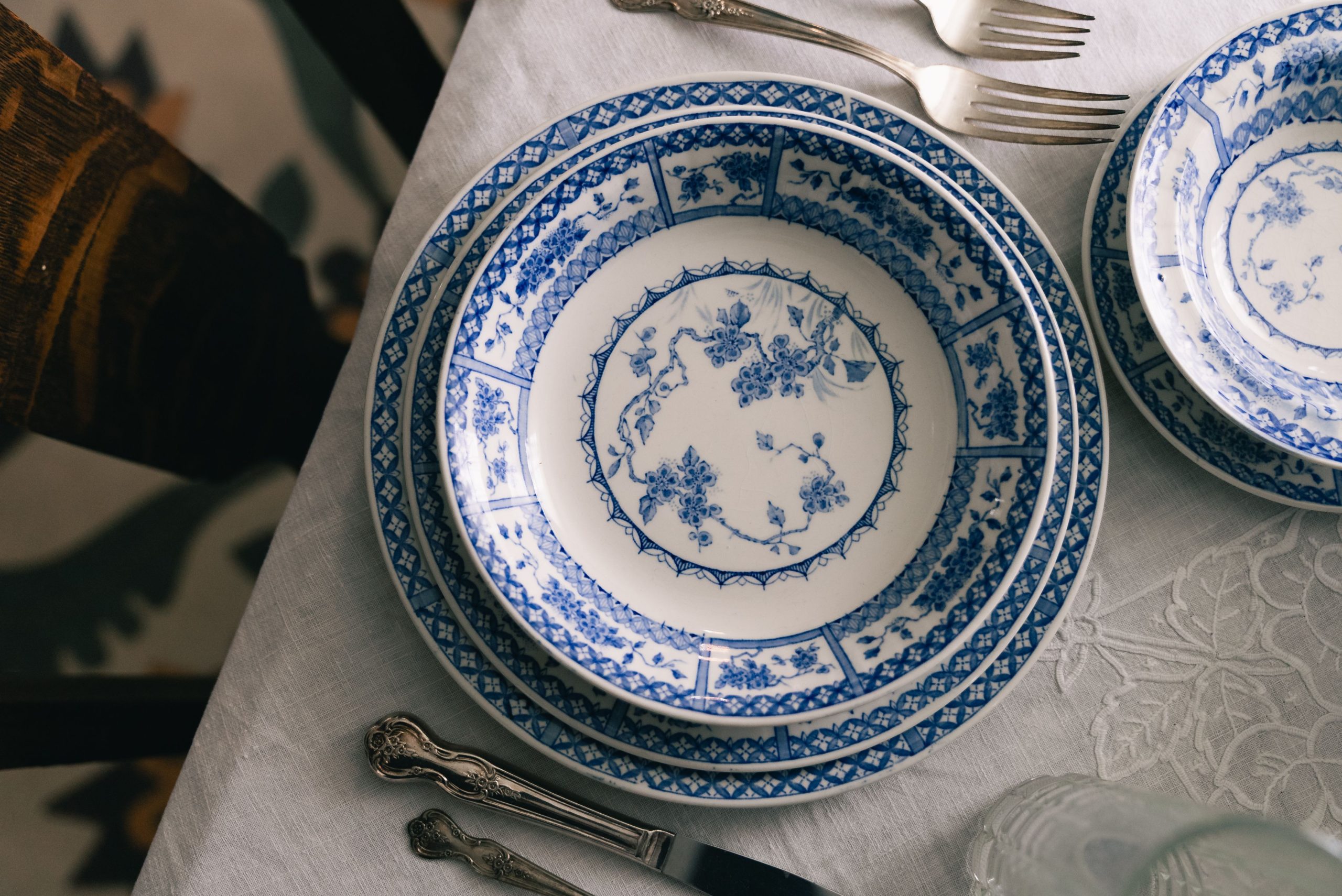 Vaisselle fleurie bleue dressée sur nappe blanche